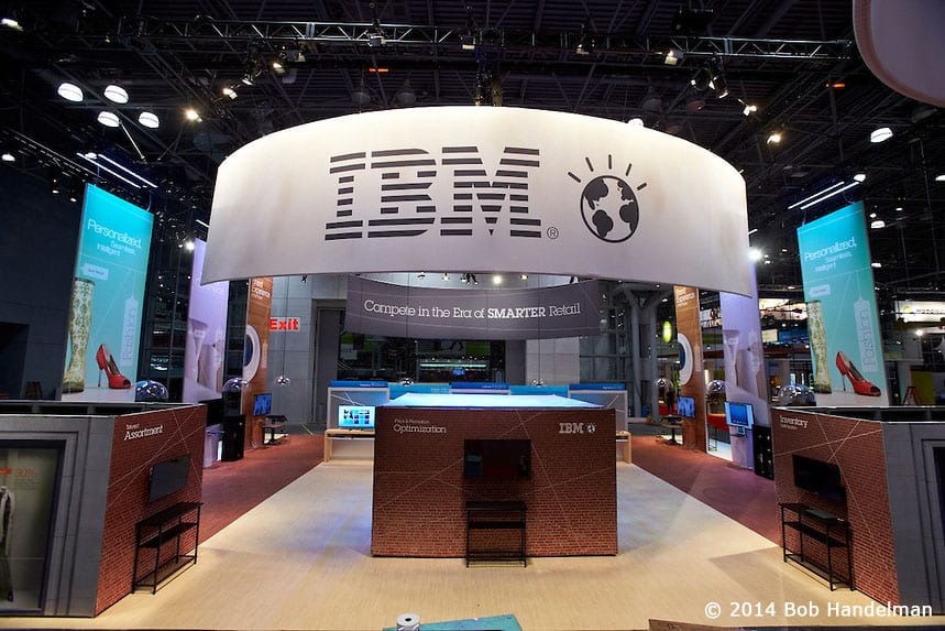 The back of the IBM booth with the central counter and tall Personalized banners