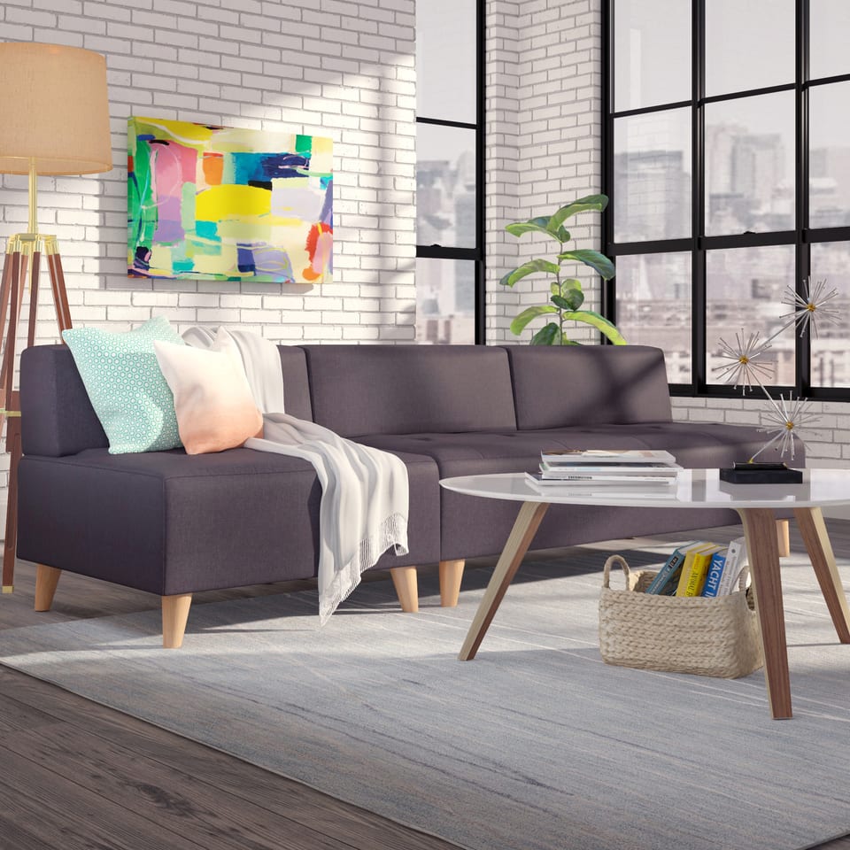 3D rendering of an urban loft with a grey sofa, brick wall and colorful artwork
